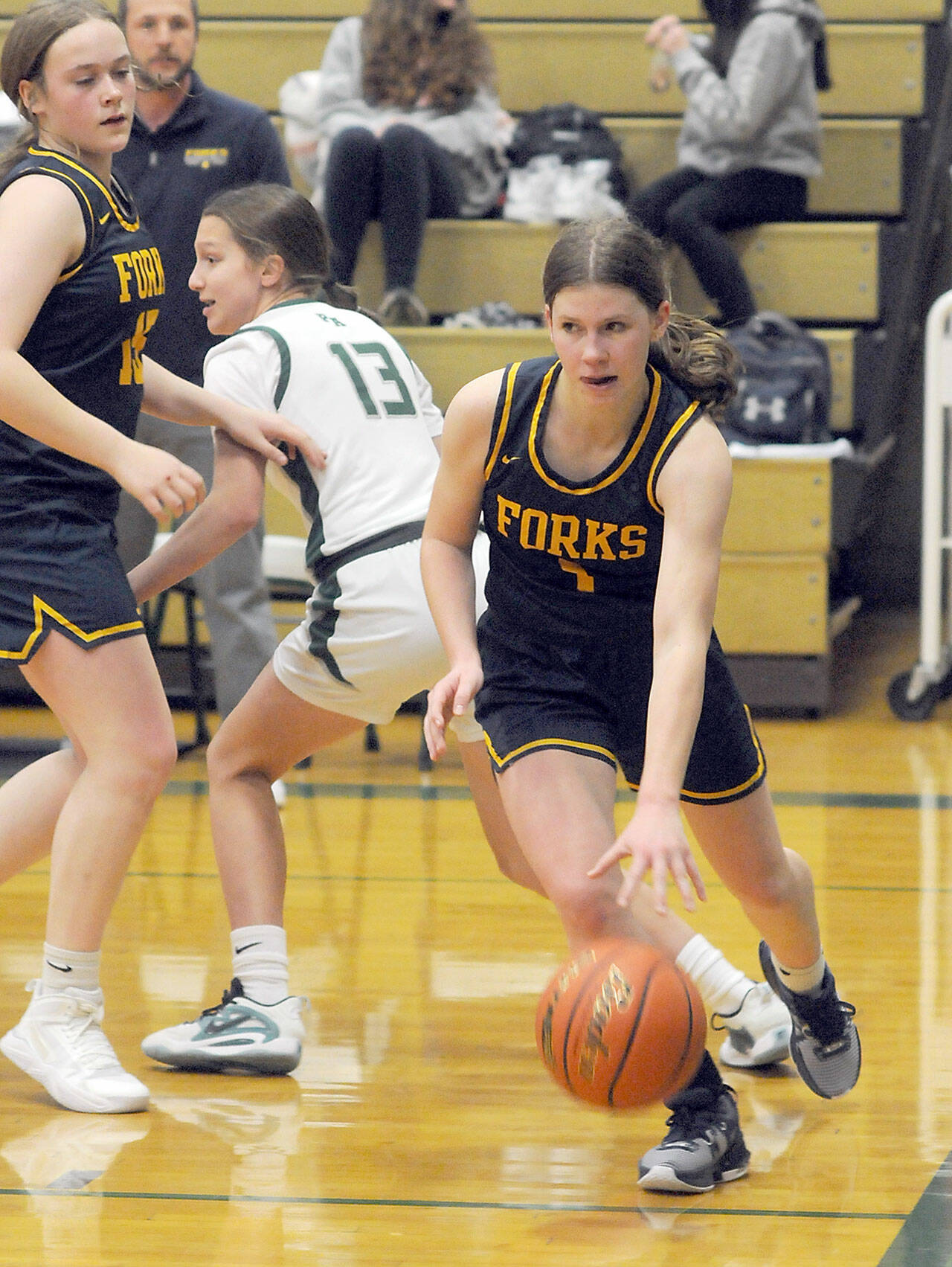 Forks’ Bailey Johnson, right, drives along the baseline as teammate Fynlie Peters, left, defends against Port Angeles’ Morgan Politika last week in Port Angeles. (Keith Thorpe/Peninsula Daily News)