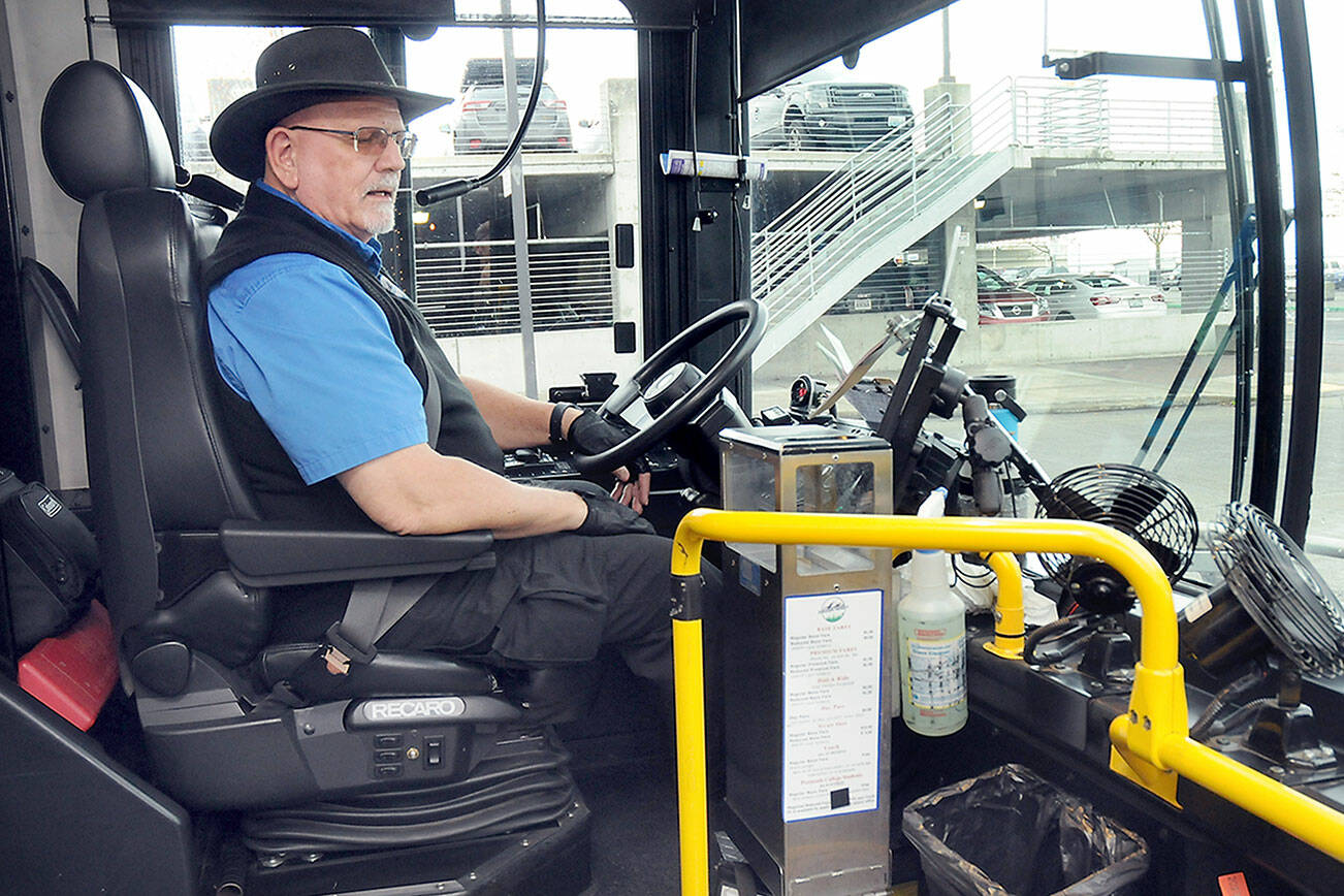 Clallam Transit driver Duane Benedict looks down at his fare box before departing The Gateway transit center in downtown Port Angeles on Saturday — the last day of collecting fares on most bus routes. (Keith Thorpe/Peninsula Daily News)
