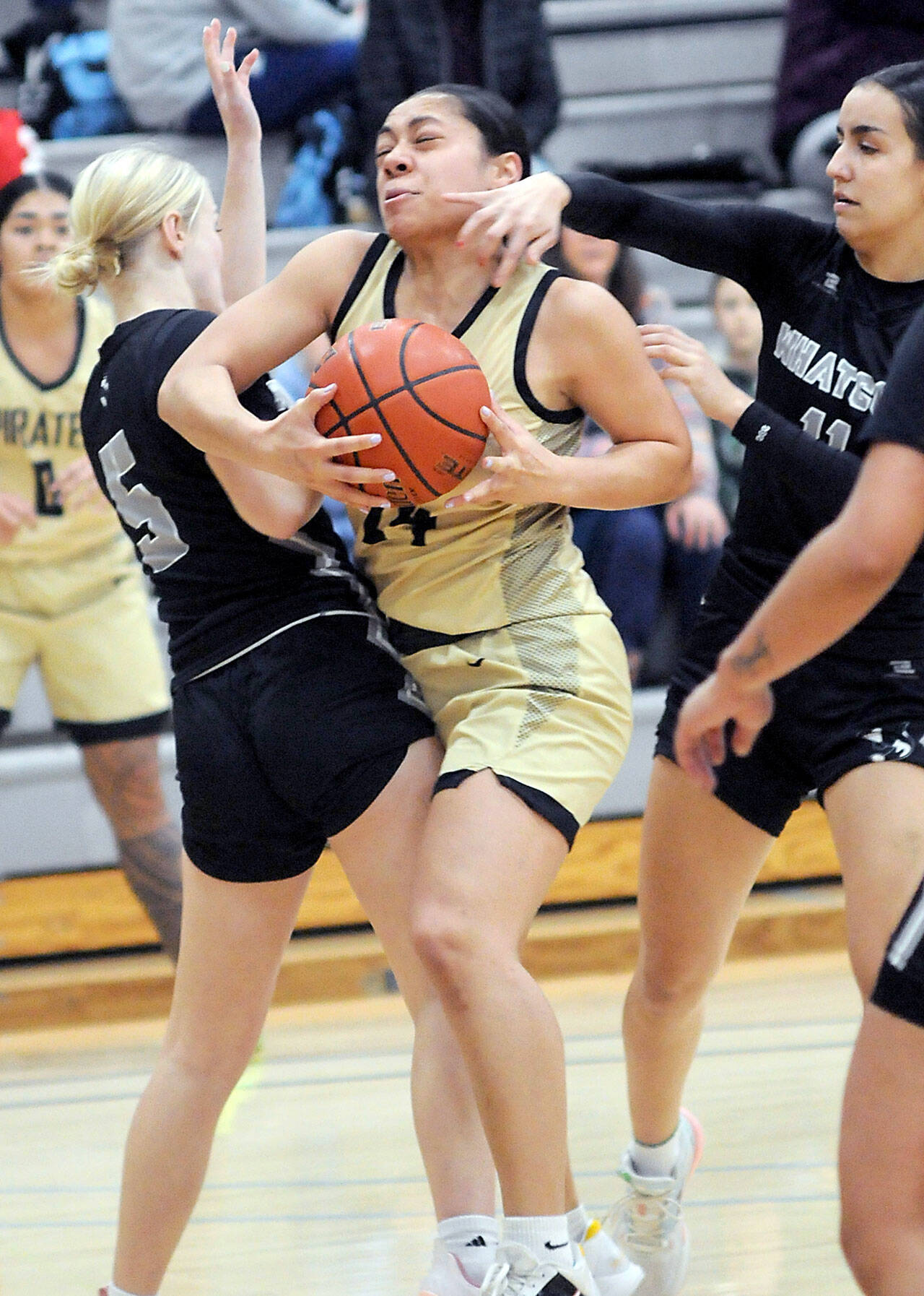 KEITH THORPE/PENINSULA DAILY NEWS Peninsula’s Shania Moananu, center, squeezes between Whatcom’s Ella Huyntington, left, and Alexa Rodriguez on Wednesday night at Peninsula College.