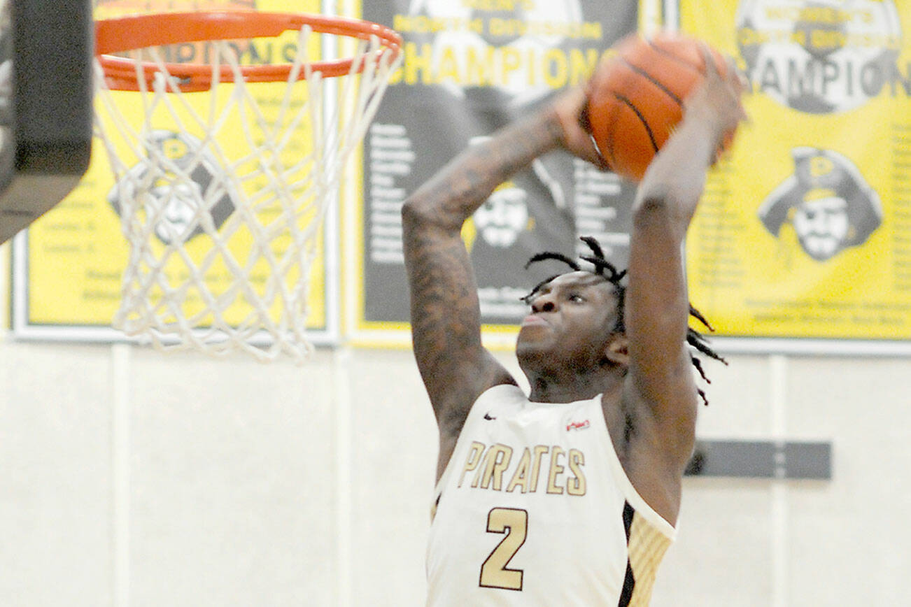 KEITH THORPE/PENINSULA DAILY NEWS 
Peninsula's Ese Onakpoma makes a slam dunk after a quick steal against Whatcom on Wednesday evening in Port Angeles. Looking on is Whatcom's Glenn Wabaluku.