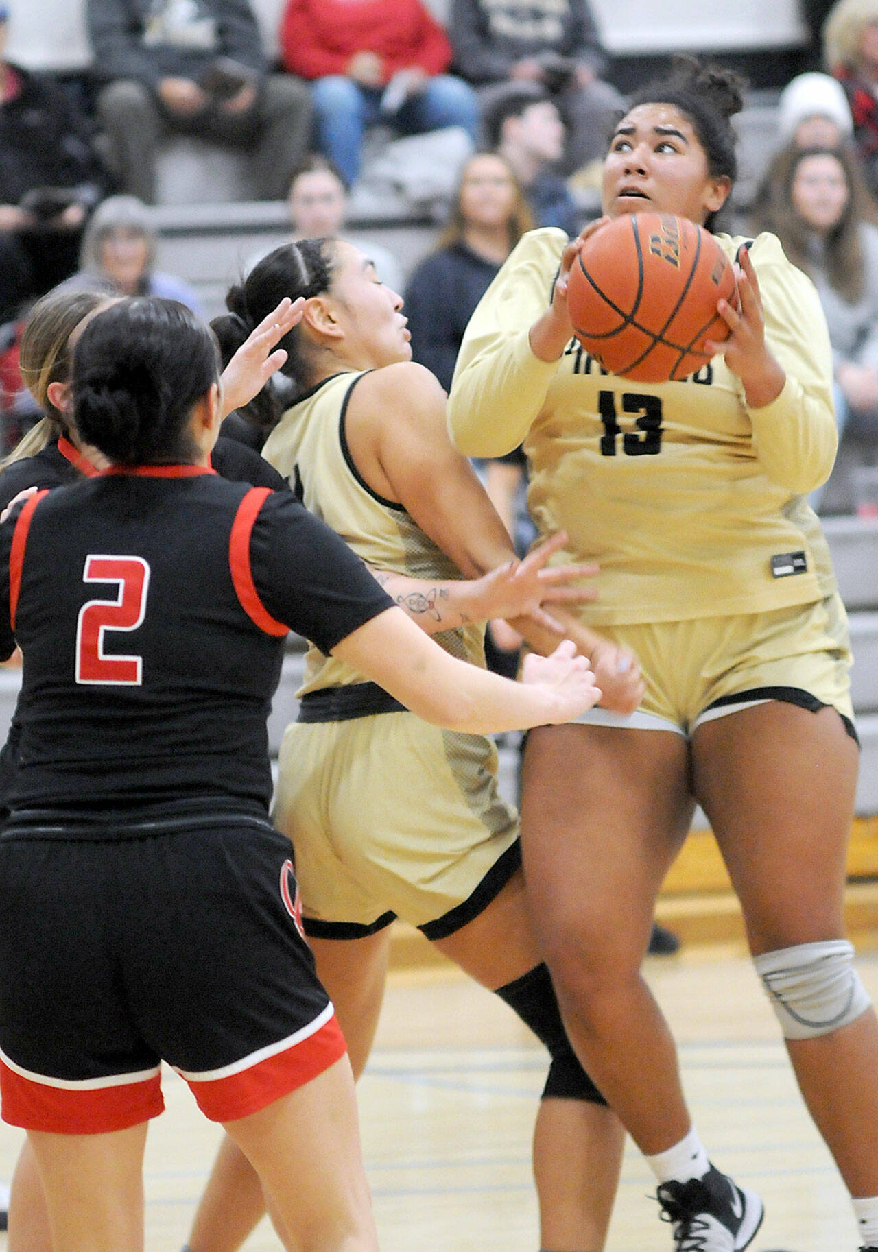 Peninsula’s Jelissa Julmist, right, looks for her chance at the goal as teammate Jenilee Donovan, center, fends off the Olympic defense, including Nohea Morrison, left, on Saturday at Peninsula College. (Keith Thorpe/Peninsula Daily News)