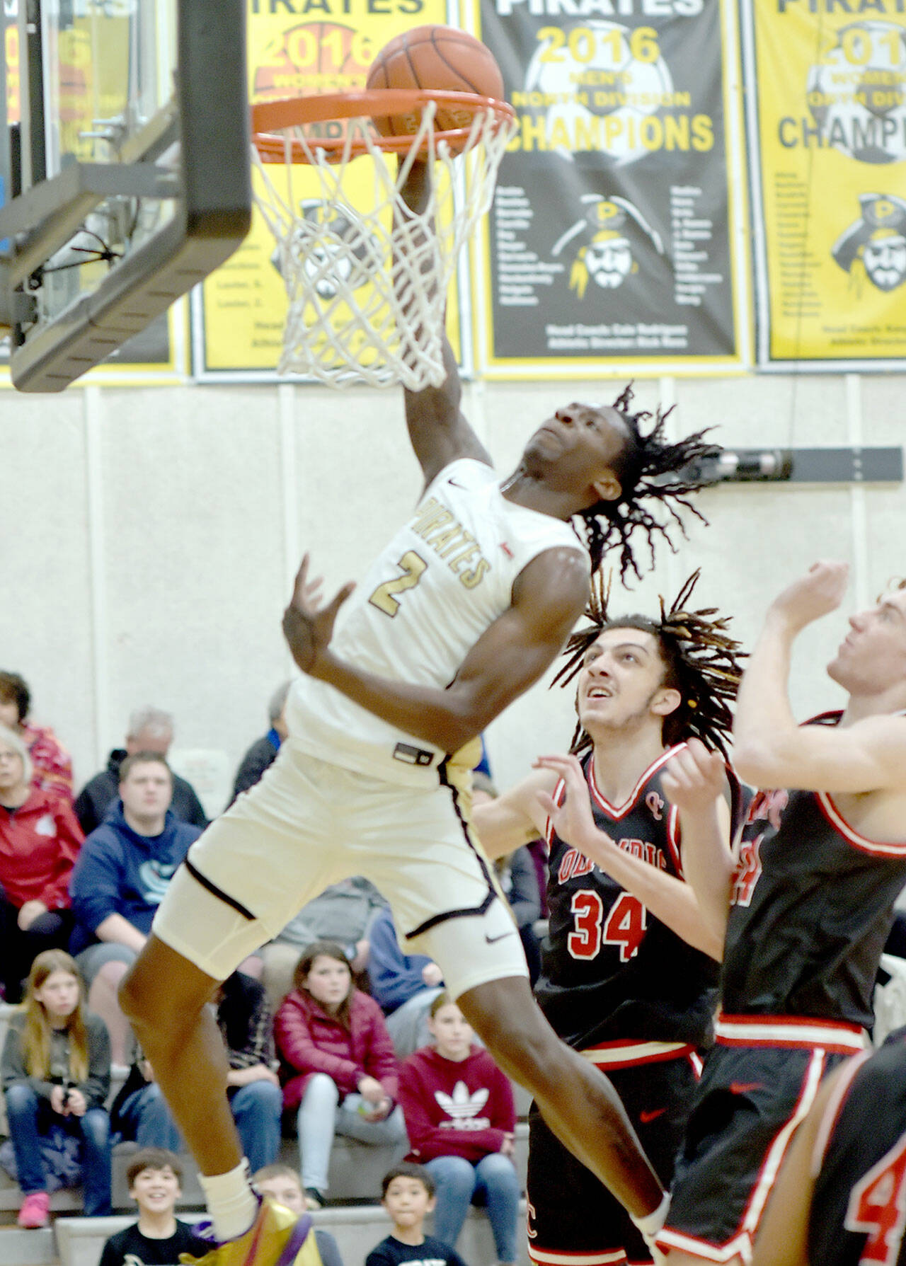 Peninsula’s Ese Onakpoma takes his turn on a slam as Olympic’s Julius Slinger, center, and Cody Ontiveros step back and watch on Saturday at Peninsula College. (Keith Thorpe/Peninsula Daily News)