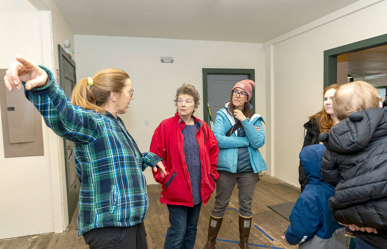 Nordland General Store Co-op CEO Patti Buckland, left, points to an area of the store to a group of visitors at the open house on Saturday in Nordland on Marrowstone Island. (Steve Mullensky/for Peninsula Daily News)
