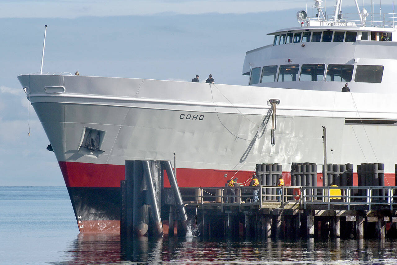 Crew members of the ferry MV Coho secure lines to the dock as the vessel returns to Port Angeles on Tuesday after being out of service since early January for annual dry dock and maintenance in Anacortes. The ferry is scheduled to resume daily service between Port Angeles and Victoria on Thursday. (Keith Thorpe/Peninsula Daily News)