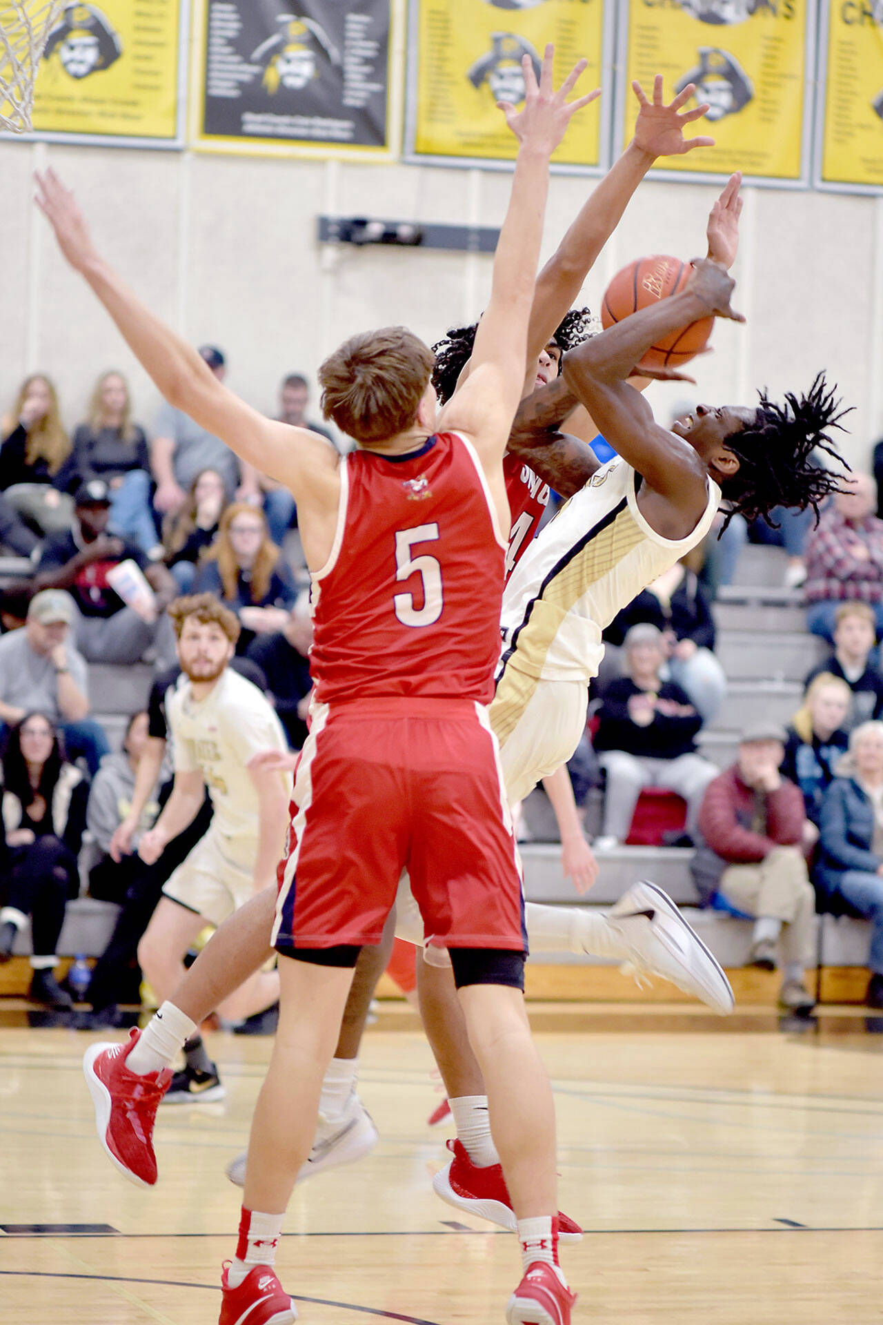 Peninsula’s Ese Onakpoma, right, fades back for the jumper surrounded by Skagit Valley’s Jacob Bilodeau, front, and Sylas Williams on Wednesday night at Peninsula College. (Keith Thorpe/Peninsula Daily News)