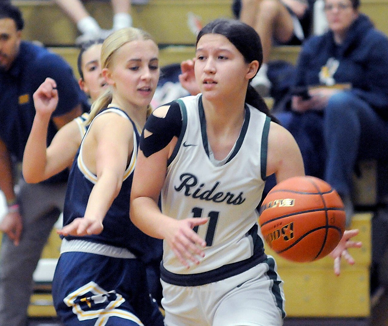 KEITH THORPE/PENINSULA DAILY NEWS Port Angeles Lindsay Smith, right, edges past Bainbridge’a Carlyn Moore on Tuesday in Port Angeles.