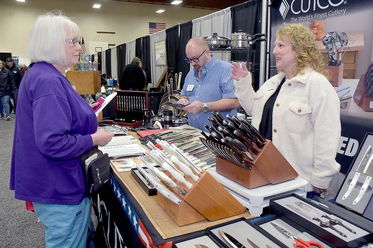 Brenda Close of Port Angeles, left, talks with Cutco Cutlery representative Allison Gilman, right, as Matt Makowicz of Cutco uses his calculator at the company’s booth at the 39th annual Clallam County Home and Lifestyle Show on Saturday at Port Angeles High School. The two-day event, hosted by KONP Radio, featured 120 exhibitor booths showcasing a wide variety of goods and services with primary sponsorship by Clallam County Public Utilities District, Lumber Traders and Leitz Farm Supply. (Keith Thorpe/Peninsula Daily News)