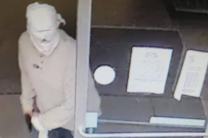 Surveillance video footage shows a man brandishing a gun at the Dollar Tree store in Port Angeles. (Clallam County Sheriff’s Office)