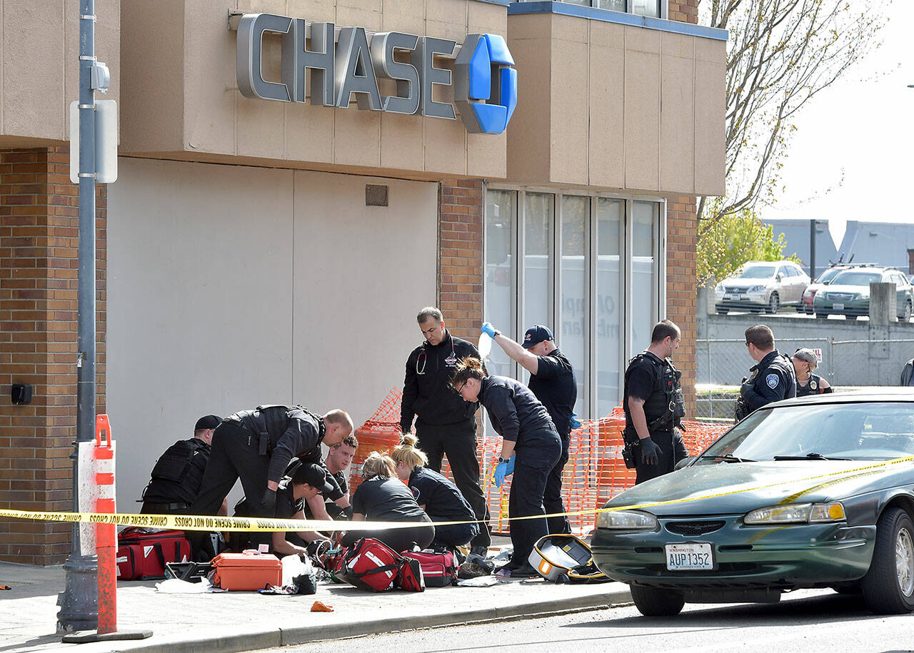 Police and rescue workers surround the scene of a disturbance on Friday morning at Chase Bank at Front and Laurel streets in downtown Port Angeles that resulted in a fatal shooting and the closure of much of the downtown area. (Keith Thorpe/Peninsula Daily News)