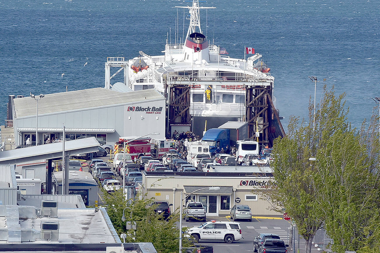 Smoke vents from the rear car deck doors as firefighters battle a vehicle fire aboard the ferry MV Coho upon its afternoon arrival in Port Angeles on Thursday. (Keith Thorpe/Peninsula Daily News)