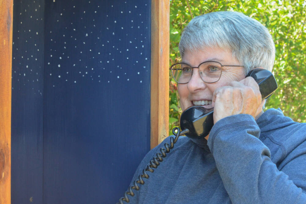 Diane Fatzinger uses the wind phone in Sequim, located just north of the Olympic Discovery Trail on West Hendrickson Road. (Elijah Sussman/Olympic Peninsula News Group)