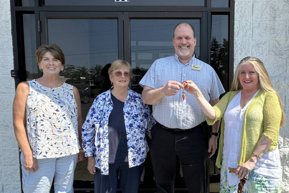 Eileen Schmitz, JACE Real Estate owner and Shipley Center board member, presents the keys of the former JCPenney building at 651 W. Washington St. to Shipley Center executive director Michael Smith following the center’s Aug. 8 purchase of the building. At far left is Joyce Gladen of JACE Real Estate, and second from left is Shipley Center board secretary Margaret Cox. (Shipley Center)