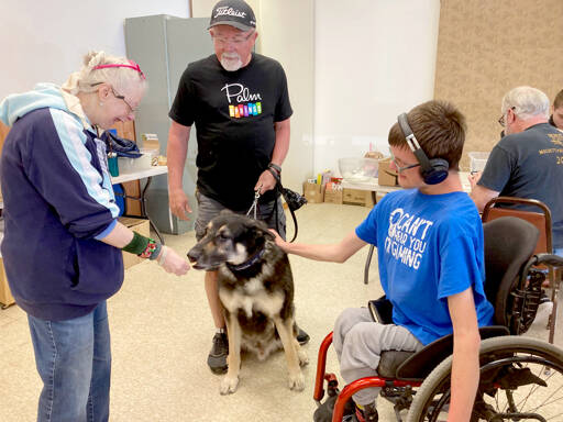 From left, Gail Jangarrd, Bob Dunbar and Sammy Dionne treat a lucky dog to a biscuit made with organic, healthy and human-grade ingredients.