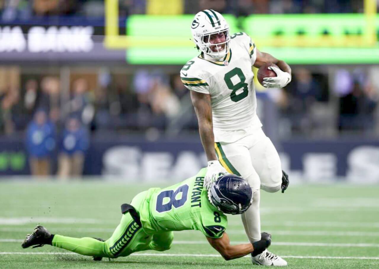 Green Bay quarterback Jordan Love tries to get away from Seattle’s Coby Bryant in Sunday night’s game at Lumen Field in Seattle. Green Bay won 30-13. (Steph Chambers/Getty Images)
