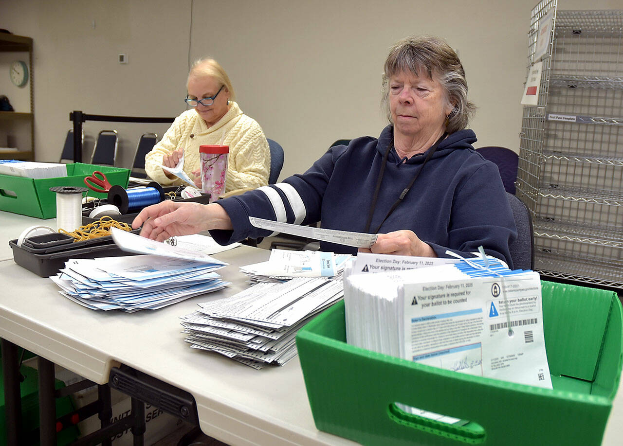 Clallam County election workers Neva Miller, right, and Debbie Kracht, both of Sequim, open election ballots on Tuesday at the courthouse in Port Angeles. (KEITH THORPE/PENINSULA DAILY NEWS)