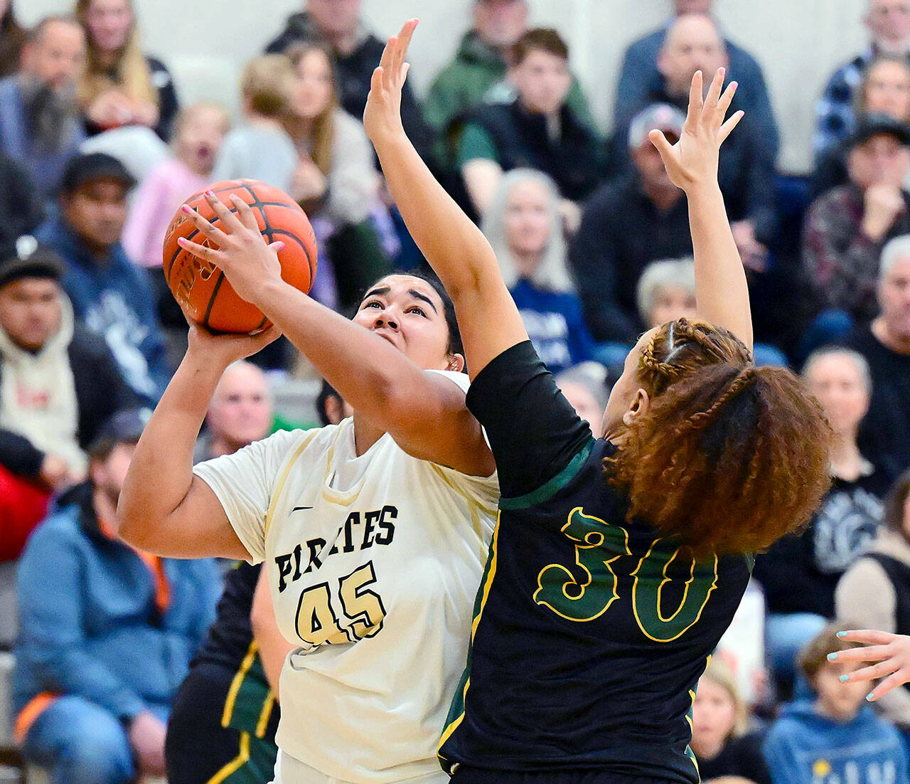 Jay Cline/Peninsula College Athletics Peninsula College’s Jelissa Julmist eyes the basket while defended by Shoreline’s FJ Tuala during the Pirates’ Sophomore Night victory Wednesday. The women celebrated their fourth straight North Division title and eighth in the programs’ history.