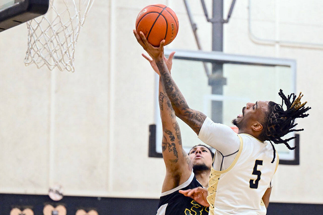 Jay Cline/Peninsula College Athletics
Peninsula's Cinco McNeal attempts a layup while defended by Shoreline's Sherrell McCullum during the Pirates' Sophomore Night defeat against the Dolphins.