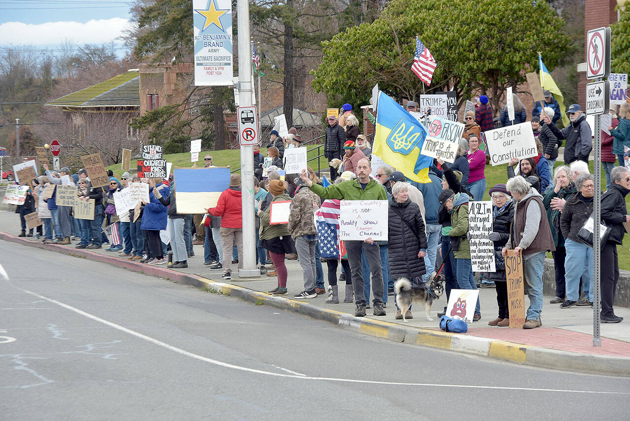 Demonstrators gather on the lawn of the Clallam County Courthouse on Tuesday in protest of the foreign and domestic policies of the Trump administration. Upwards of 100 people took part in the event. (Keith Thorpe/Peninsula Daily News)