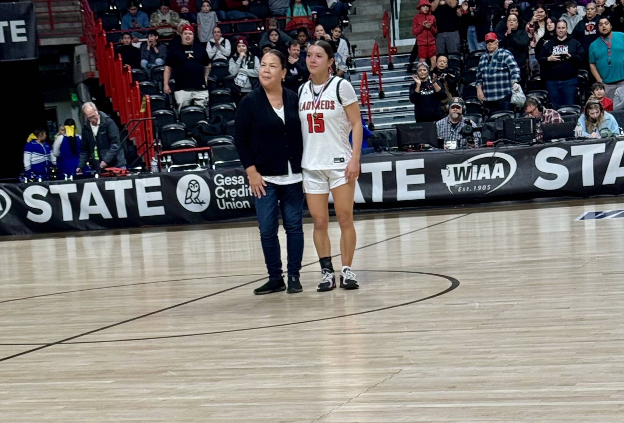 Courtesy Bud Denney 
Neah Bay’s Qwaapeys Greene, right, received the WIAA Sportsmanship Medallion from Lauri McCaulley for her play in the Red Devils’ 51-36 state quarterfinal win over Oakesdale on Thursday at the Spokane Arena.