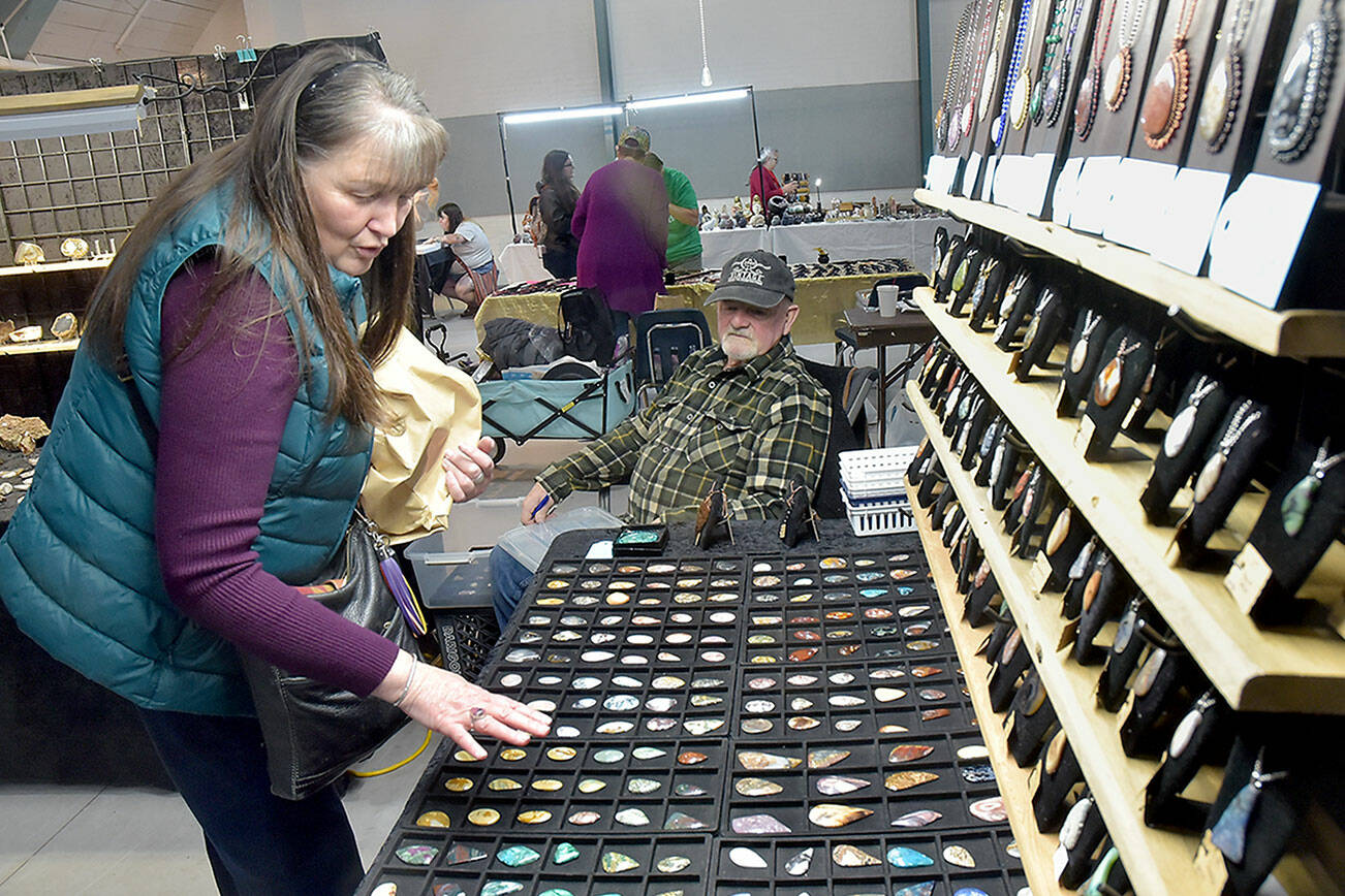 Jeannine Vaughn of Carlsborg looks a gems and jewelry at a display table operated by Steve Morgan of Joyce-based Lil’ Log Cabin Creations on Saturday at the Clallam County Rock, Gem and Jewelry Show at Vern Burton Community Center in Port Angeles. The show, hosted by the Clallam County Gem & Mineral Association, brought together rock enthusiasts with vendor booths and demonstrations highlighting the hobby. (Keith Thorpe/Peninsula Daily News)