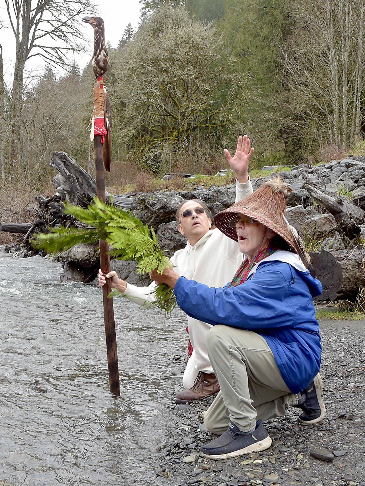 Lummi Nation member Freddie Lane, whose tribal name is Sul Ka Dub, left, and tribal elder Richard Solomon, known as Hutch Ak Wilton, kneel along the banks of the Elwha River in Olympic National Park on Friday to ceremonially ask permission to be at the river in preparation for World Water Day festivities in Port Angeles. Lane, along with members of the Lower Elwha Klallam Tribe, will take part in an opening ceremony at 11 a.m. today at Hollywood Beach, followed by an interfaith water blessing at nearby Pebble Beach Park. Other World Water Day activities include guided nature hikes, environmentally themed films at the Little Theater at Peninsula College and a performance by Grammy Award-winning indigenous artist Star Nayea. (Keith Thorpe/Peninsula Daily News)