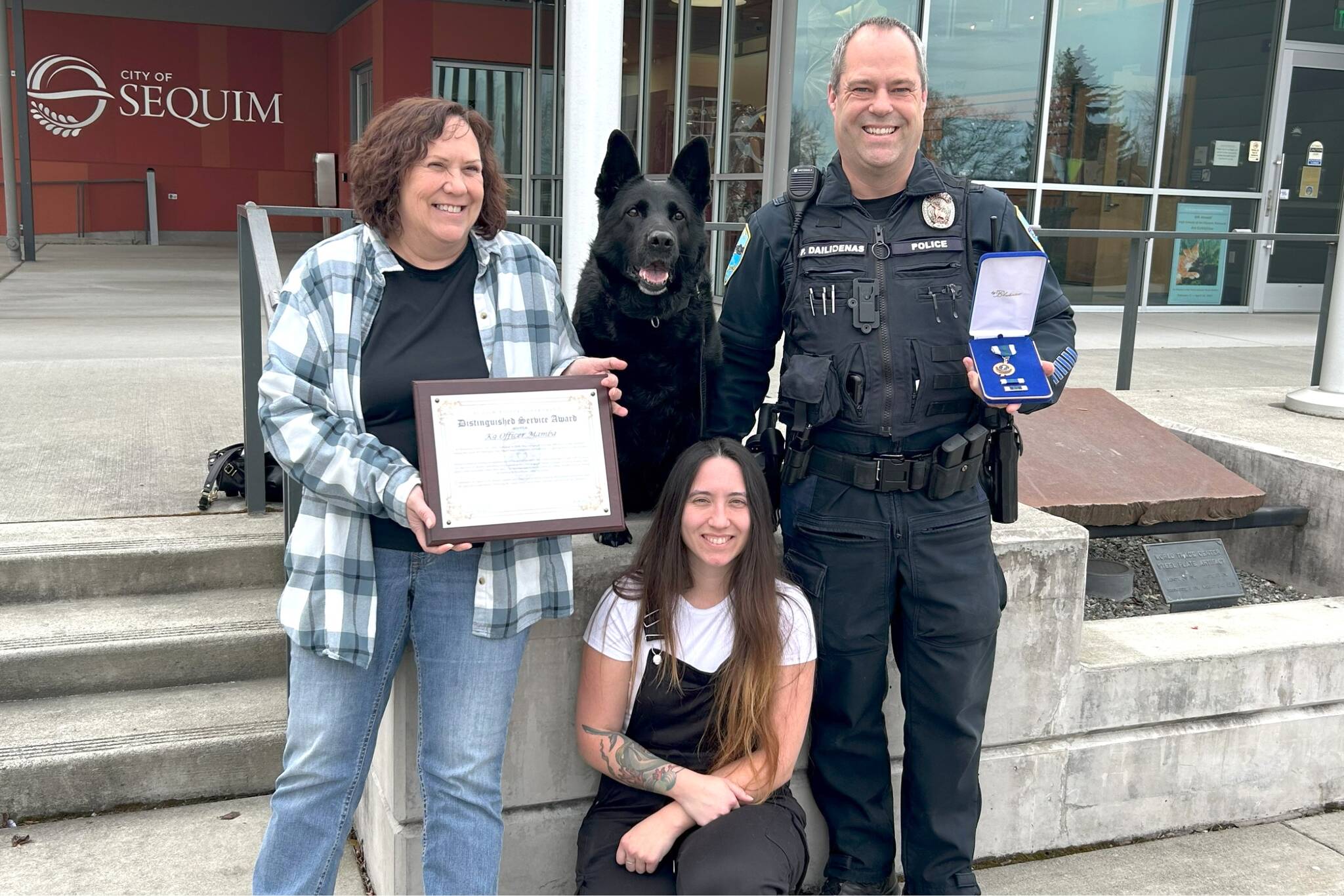 Matthew Nash/Olympic Peninsula News Group
Mamba sits at the Sequim Civic Center with her family — Sequim Police Officer Paul Dailidenas, his wife Linda, left, and their daughter Alyssa on March 10 after Dailidenas and Mamba received a Distinguished Medal. Mamba retired from service after nearly eight years, and Sequim is training another officer and dog to take over the K-9 Officer Program with Dailidenas’ blessing.