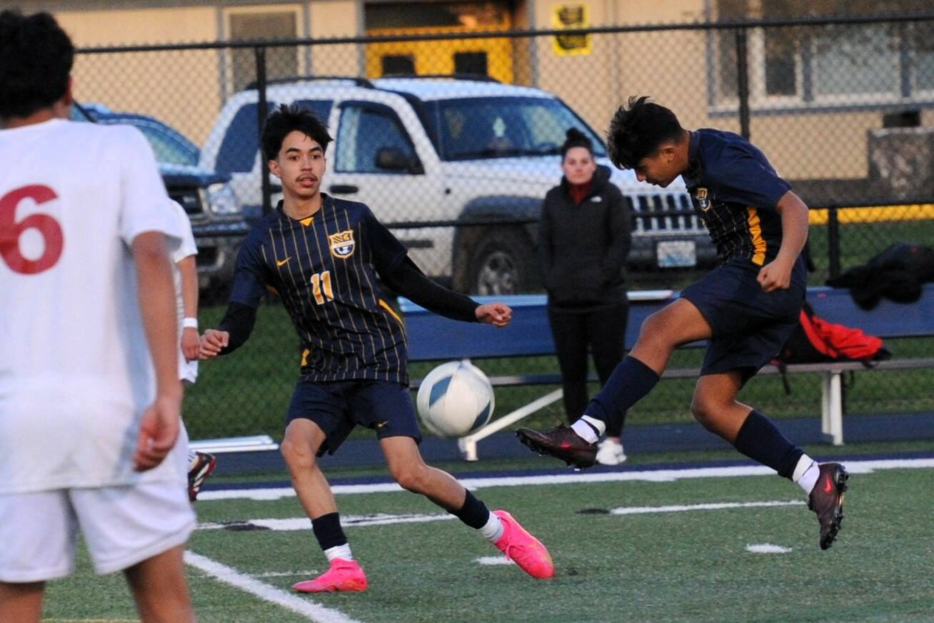 Lonnie Archibald/for Peninsula Daily News 
Forks’ Orlando Camacho kicks the ball past Hoquiam defenders including Israel Rosales (6). Also in action for Forks is Margarito Gonzalez Black (11). The Spartans scored four second-half goals to beat the Grizzlies 5-1.