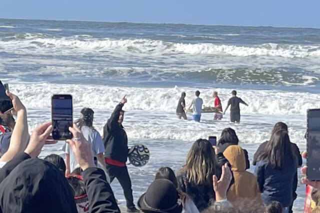 Four Quileute Tribal School students take a salmon offering into the ocean as part of the annual Welcoming the Whales ceremony at First Beach in La Push on Friday. (Christi Baron/Olympic Peninsula News Group)