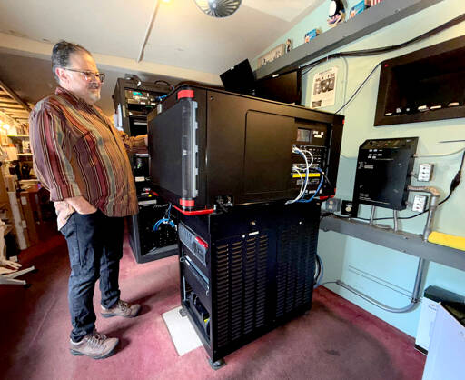 Jason Squire, manager of the Rose Theatre in Port Townsend, shows off the new $150,000 Barco SP4K laser projector installed last month. The projector, one of three that the movie house needs for each of its screens, replaces an aging one that failed in June 2024, necessitating a GoFundMe drive for the owners, George Marie and Michael D’Alessandro, to help pay for a new one. More than $105,000 was raised from 777 donors. (Steve Mullensky/for Peninsula Daily News)