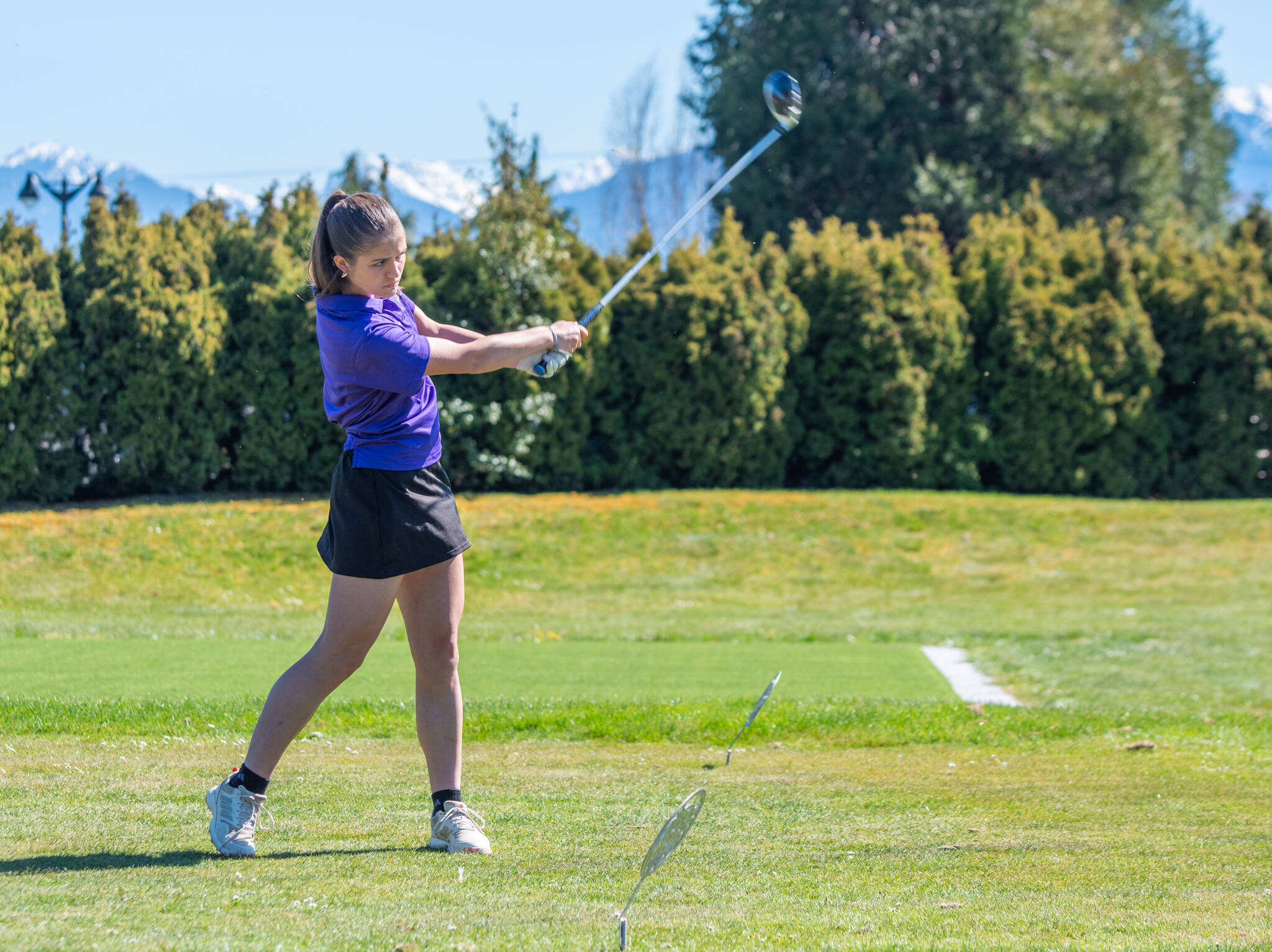 Sequim’s Raimey Brewer completes her swing and eyes her drive during the Wolves’ Olympic League girls golf match with Olympic at The Cedars at Dungeness on Thursday. (Emily Matthiessen/Olympic Peninsula News Group)