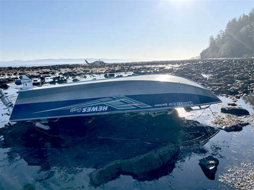 A 15-foot pleasure craft sits capsized at Koitlah Point on Thursday. U.S Coast Guard, local and federal agencies responded to a report of an overdue vessel with three people on board after they failed to return Wednesday evening. (U.S. Coast Guard)