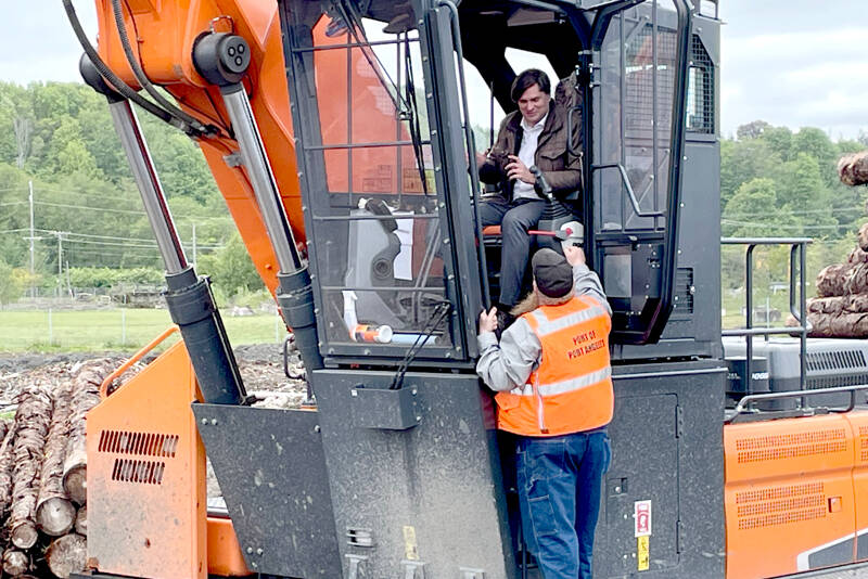 State Treasurer Mike Pellicciotti, in cab, gets guidance operating a Develon DX300LL-5 log loader on Tuesday from Port of Port Angeles log yard equipment operator Jodie O’Neel. The port purchased the $449,000 log loader through the Office of the State Treasurer LOCAL government financing program, which provides municipalities with low-cost loans for equipment and real estate purchases. Pellicciotti visited Port Angeles to talk about the LOCAL program. (Paula Hunt/Peninsula Daily News)
