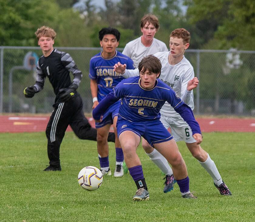 Emily Mathiessen/Olympic Peninsula News Group
Sequim’s Finn Braaten (5) and Evan Cisneros (17) battle for the ball against Port Angeles’ Sawyer Davis (6). Port Angeles goalkeeper Gus Halberg (1) is also in on the play. Sequim won 1-0 Friday in Sequim.