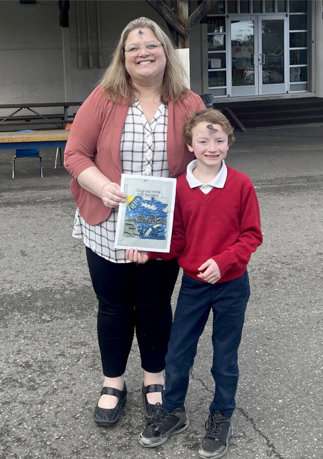 Dennis Tisdale of Queen of Angels school and his winning medal design for the North Olympic Discovery Marathon kids’ marathon. With him is Queen of Angeles principal Ceci Kimball. (Port Angeles Marathon Association)