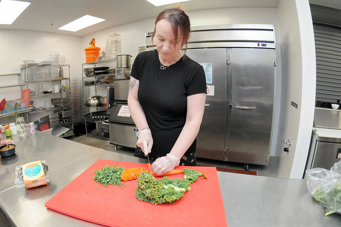 Kayla Fairchild, culinary manager for the Port Angeles Food Bank, chops vegetables on Friday that will go into ready-made meals for food bank patrons. (Keith Thorpe/Peninsula Daily News)