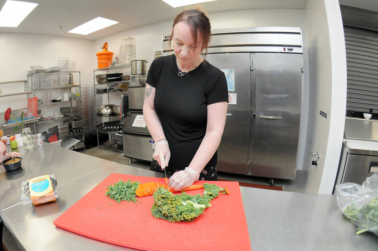 Kayla Fairchild, culinary manager for the Port Angeles Food Bank, chops vegetables on Friday that will go into ready-made meals for food bank patrons. (Keith Thorpe/Peninsula Daily News)