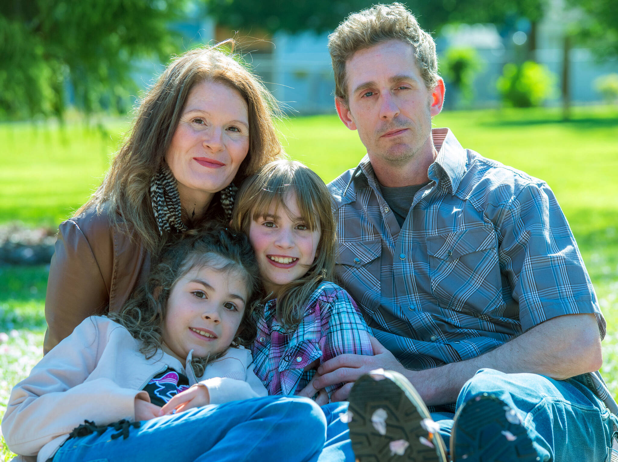 The Hanshaw family is struggling under the weight of emotional and financial stressors brought by the recent diagnoses by doctors at Seattle Children’s Hospital that have finally answered the question of why Ember, center, has always been frail. Shown with Ember are her parents, Jennifer and Tim Hanshaw, and 9-year-old sister Lena, who shares a hereditary condition with her father and sister. (Emily Matthiessen/Olympic Peninsula News Group)