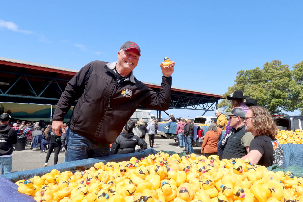 Bill Schlichting, Wilder Toyota sales manager, holds up the rubber duck belonging to Colleen Williams of Port Angeles, winner of the 2025 Toyota Corolla, at the 36th annual Great Olympic Peninsula Duck Derby held at City Pier in Port Angeles on Sunday. (Dave Logan/For Peninsula Daily News)