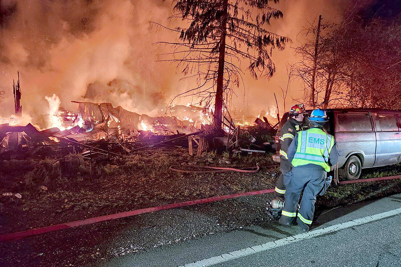 First responders assess a structure fire Thursday night on U.S. Highway 101 between Quilcene and Brinnon. (Jefferson County Sheriff’s Office via X)