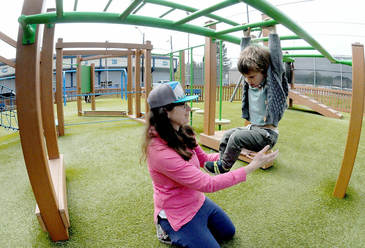 Elizabeth Angell of Port Angeles keeps watch on her son, Myles Angell, 2, during an outing at the Dream Playground at Erickson Playfield on Wednesday in Port Angeles. Portions of the playground are currently closed for maintenance and the entire playground is scheduled to be closed on Saturday morning for seasonal play surface rehabilitation. (Keith Thorpe/Peninsula Daily News)