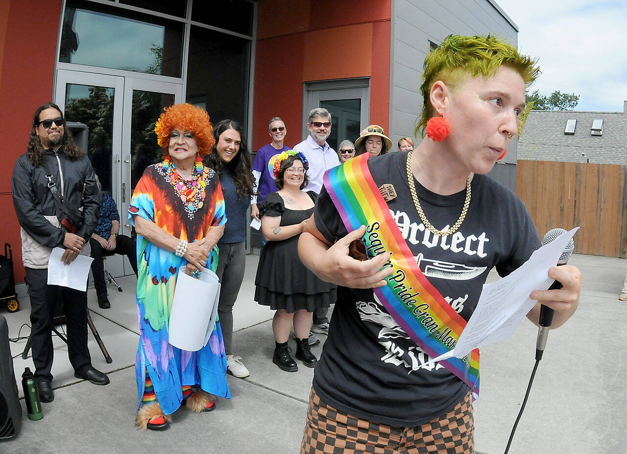 Jaiden Dokken, former Clallam County poet laureate and grand marshal of the 2025 Sequim Pride Parade, addresses the audience of Sequim Pride from the steps of Sequim City Hall during Saturday’s Sequim Farmers & Artisans Market. The event, celebrating Pride Month to honor the area’s LGBTQIA2S+ community, featured speeches and a march around downtown Sequim with more than 200 participants followed by a group photo at the city hall plaza. (Keith Thorpe/Peninsula Daily News)