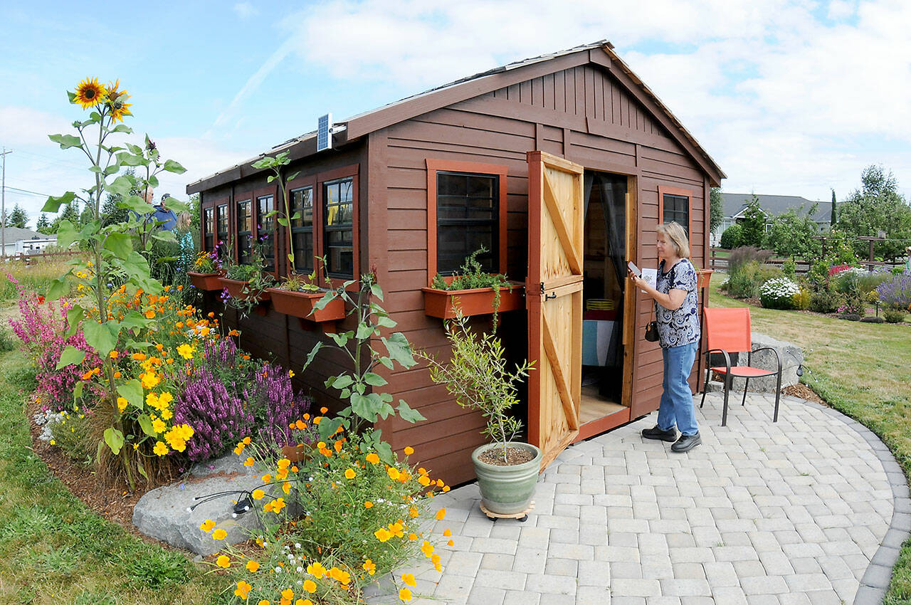 Peggy Finsterbusch of Port Angeles examines an outbuilding at the Sequim home of Amy Chance and Terry Anderson, a participating garden during the 30th annual Petals & Pathways Home Garden Tour. The event showcased eight gardens in the Sequim and Port Angeles areas, arranged and coordinated by the Master Gardener Foundation of Clallam County. (Keith Thorpe/Peninsula Daily News)