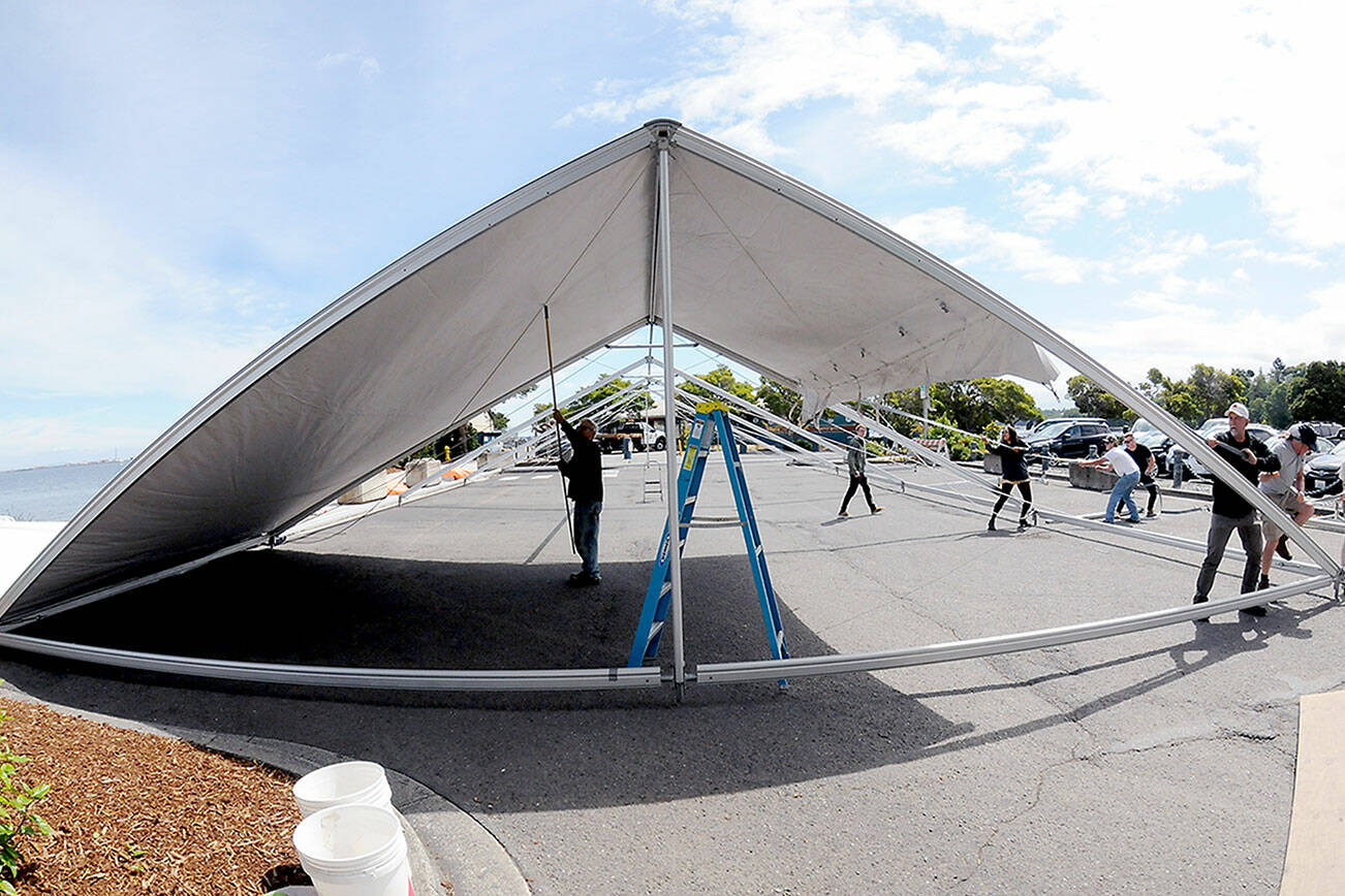 KEITH THORPE/PENINSULA DAILY NEWS
A crew erects an activity tent on Thursday in the parking lot of Port Angeles City Pier in preparation for today's Independence Day events. For a list of July 4 activities, see today's on-line edition of the Peninsula Daily News.