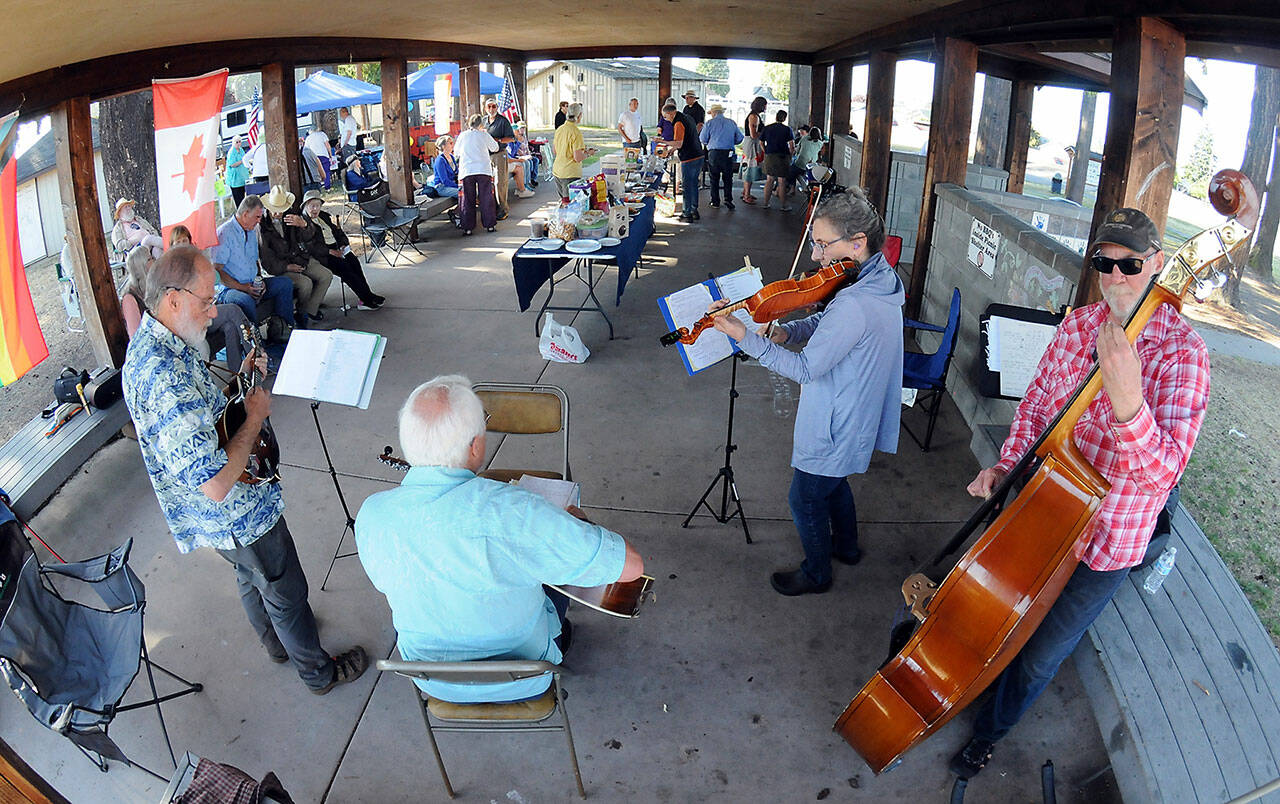 Members of the musical group Soupbones, from left, Ed Schmid of Port Angeles, Ron Munro of Sequim, Carly List of Port Angeles and Hugh Starks of Sequim, perform at a Good Trouble community gathering and picnic on Thursday at Erickson Playfield in Port Angeles. Organizers of the event, one of numerous gatherings across the United States, decided to forego conventional politics while commemorating the life of civil rights activist John Lewis. (Keith Thorpe/Peninsula Daily News)