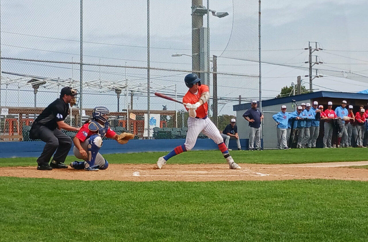 Port Angeles' Jack Edmunds hits an RBI single in the first inning against the Victoria HarbourCats. (Pierre LaBossiere/Peninsula Daily News)
