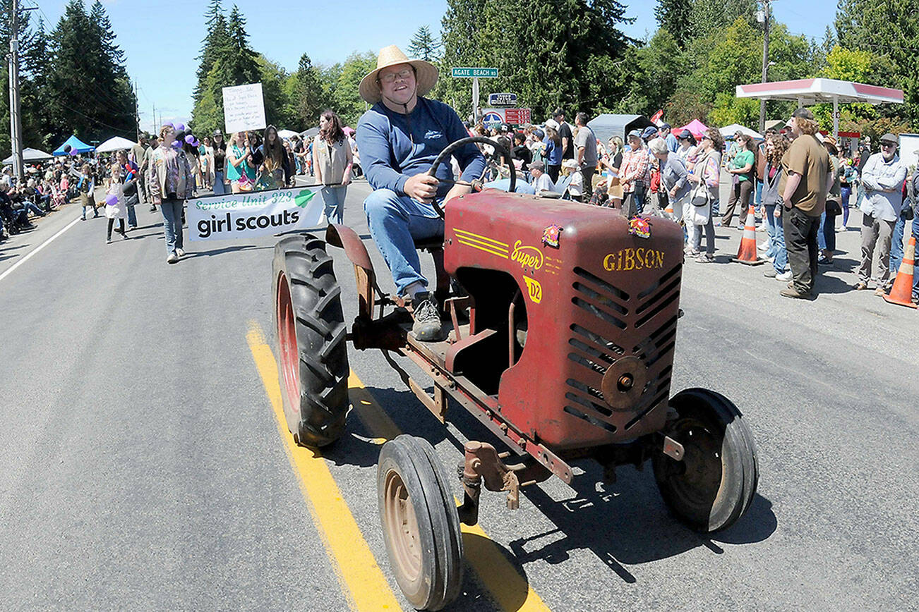 Darren Peacock drives a 1949 Gibson Super D2 tractor down state Highway 112 during Saturday’s Joyce Daze Wild Blackberry Festival grand parade. (Keith Thorpe/Peninsula Daily News)