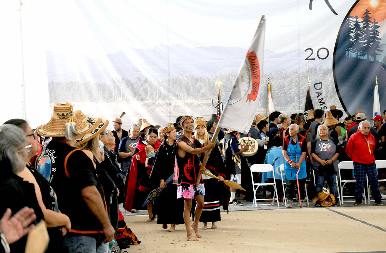 Quileute tribal member Devin Coberly-Black carries the tribe’s banner as dancers enter the performance area at the Paddle to Elwha 2025 celebration on Tuesday at the Lower Elwha Klallam Tribal Reservation west of Port Angeles. Native bands from around the region took part in the five-day event following the arrival of dozens of tribal canoes last Thursday. Festivities concluded on Tuesday with traditional dances and songs by native groups from across the Peninsula. (Keith Thorpe/Peninsula Daily News)