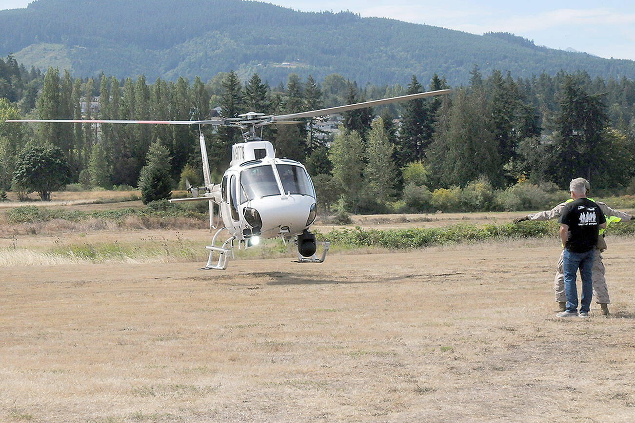 A surveillance and patrol helicopter operated by the U.S. Department of Homeland Security lands at Saturday’s Unity of Effort festival of military, law enforcement and first responders in Sequim. The event, hosted by Security Services Northwest, featured a variety of military equipment, law enforcement and public safety displays, food, music and other activities as well as a helicopter fly-in. (Keith Thorpe/Peninsula Daily News)