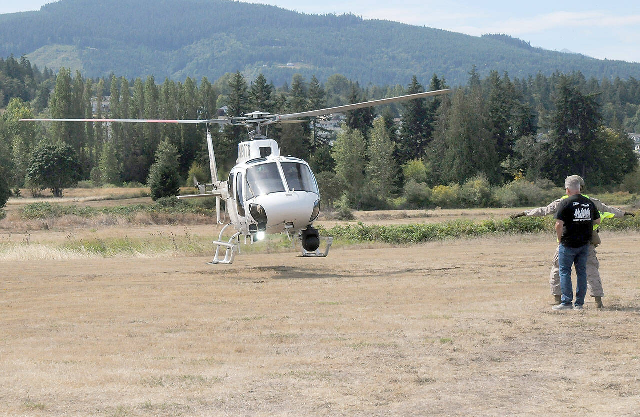 A surveillance and patrol helicopter operated by the U.S. Department of Homeland Security lands at Saturday’s Unity of Effort festival of military, law enforcement and first responders in Sequim. The event, hosted by Security Services Northwest, featured a variety of military equipment, law enforcement and public safety displays, food, music and other activities as well as a helicopter fly-in. (Keith Thorpe/Peninsula Daily News)