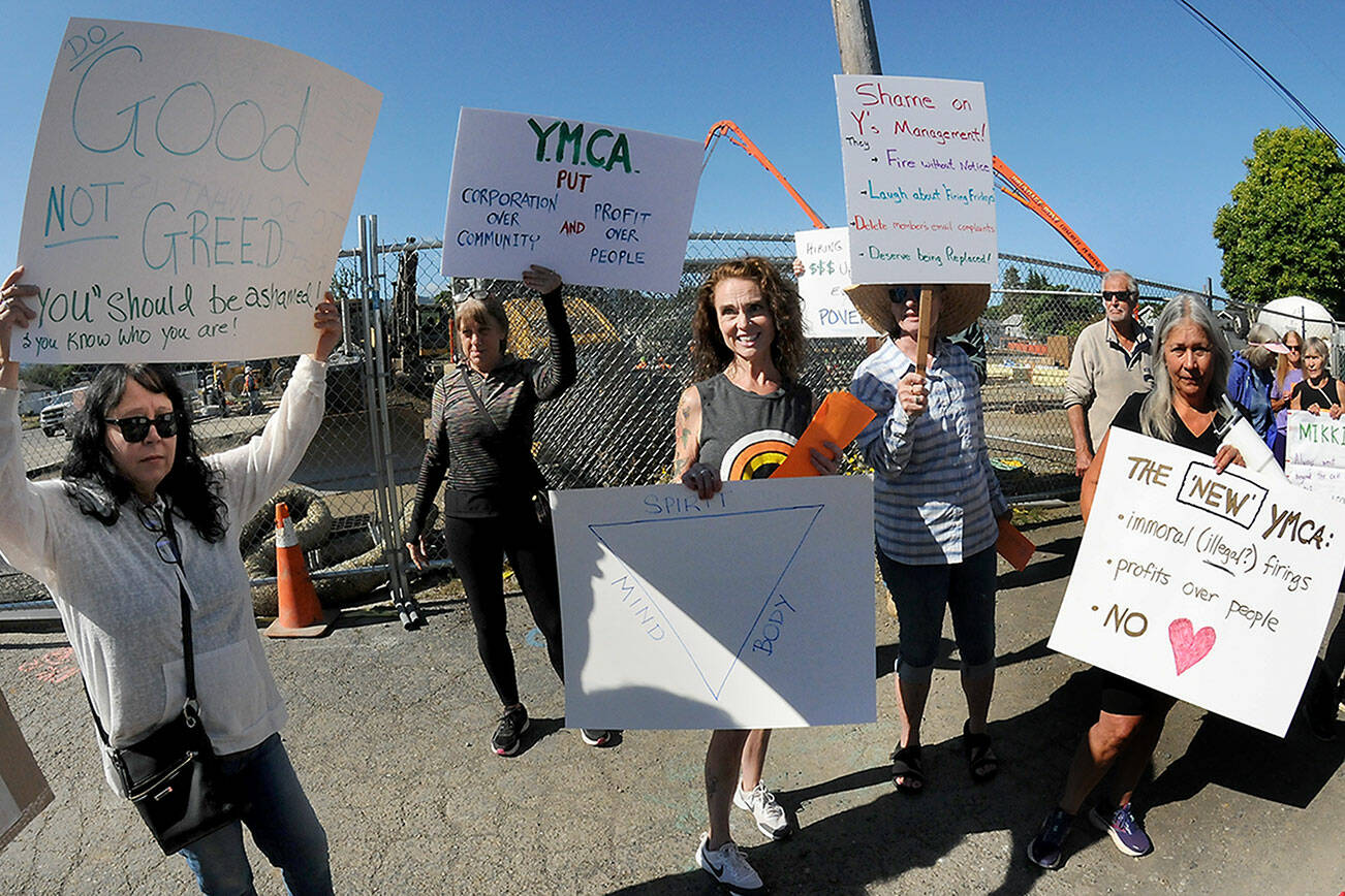 Former Olympic Peninsula YMCA employee Mikki Hughes, center, stands on Wednesday in front of the Port Angeles YMCA with friends and co-workers who protested Hughes’ dismissal from her longtime duties as fitness instructor and fitness coordinator. (Keith Thorpe/Peninsula Daily News)